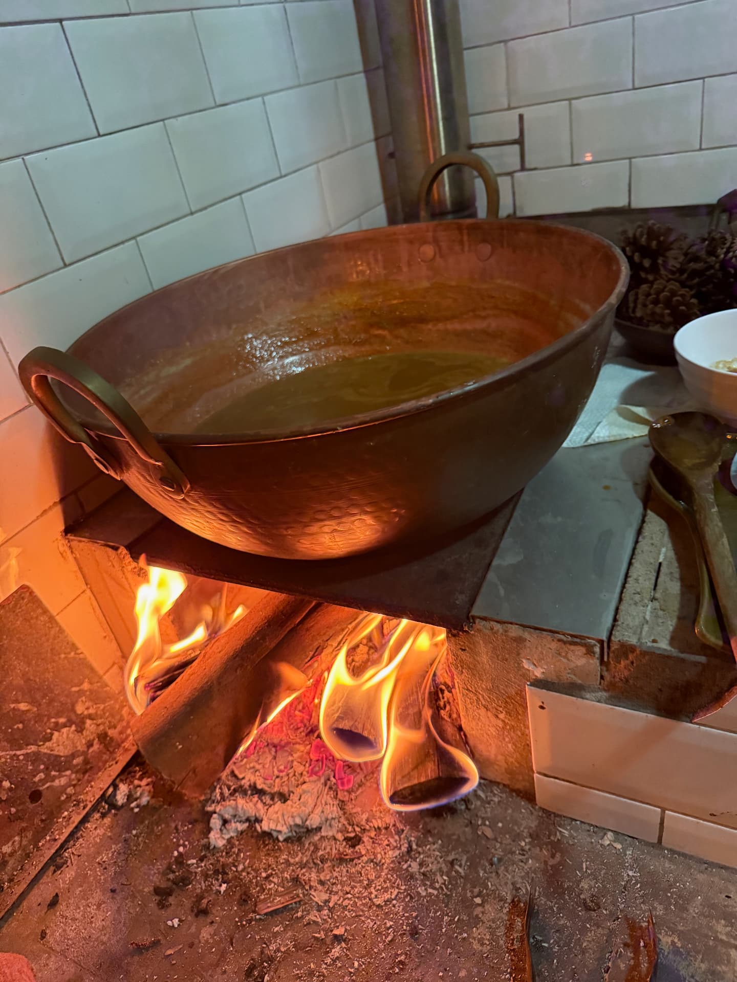 Doce cozinhando em tacho de cobre sobre o fogo de lenha
