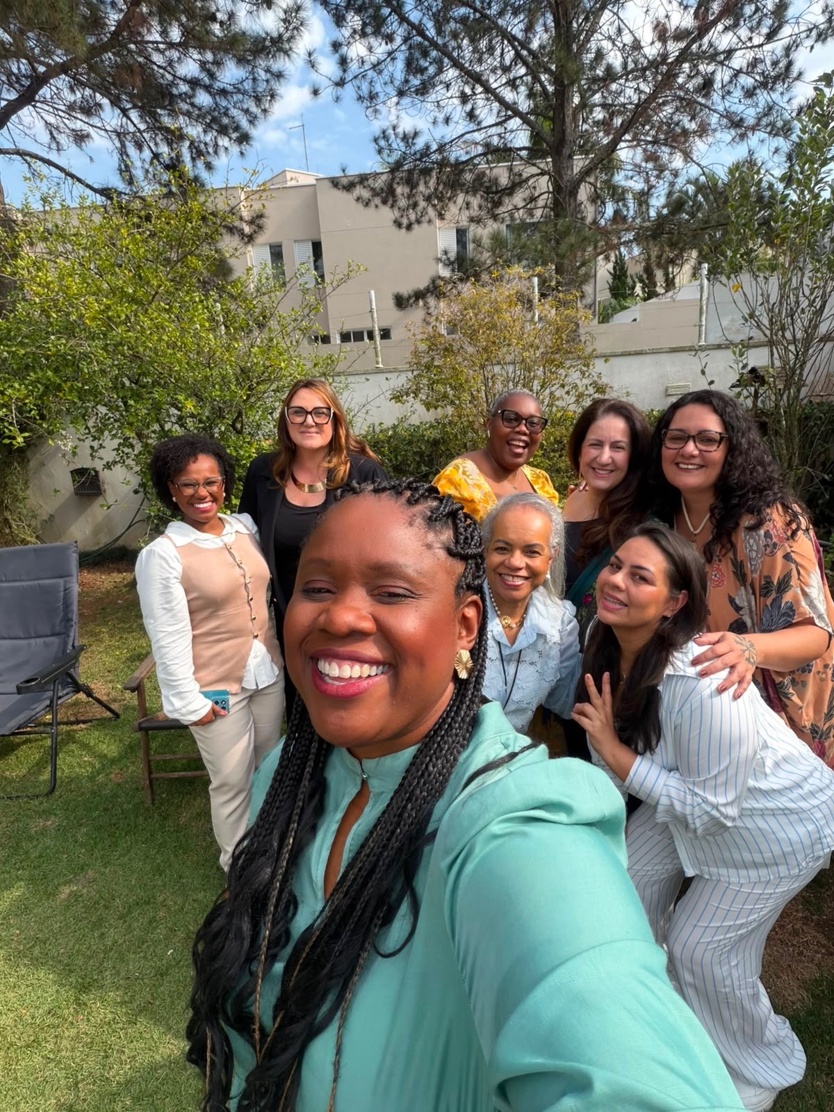 Grupo de amigas sorrindo em uma selfie no quintal do Prosa
