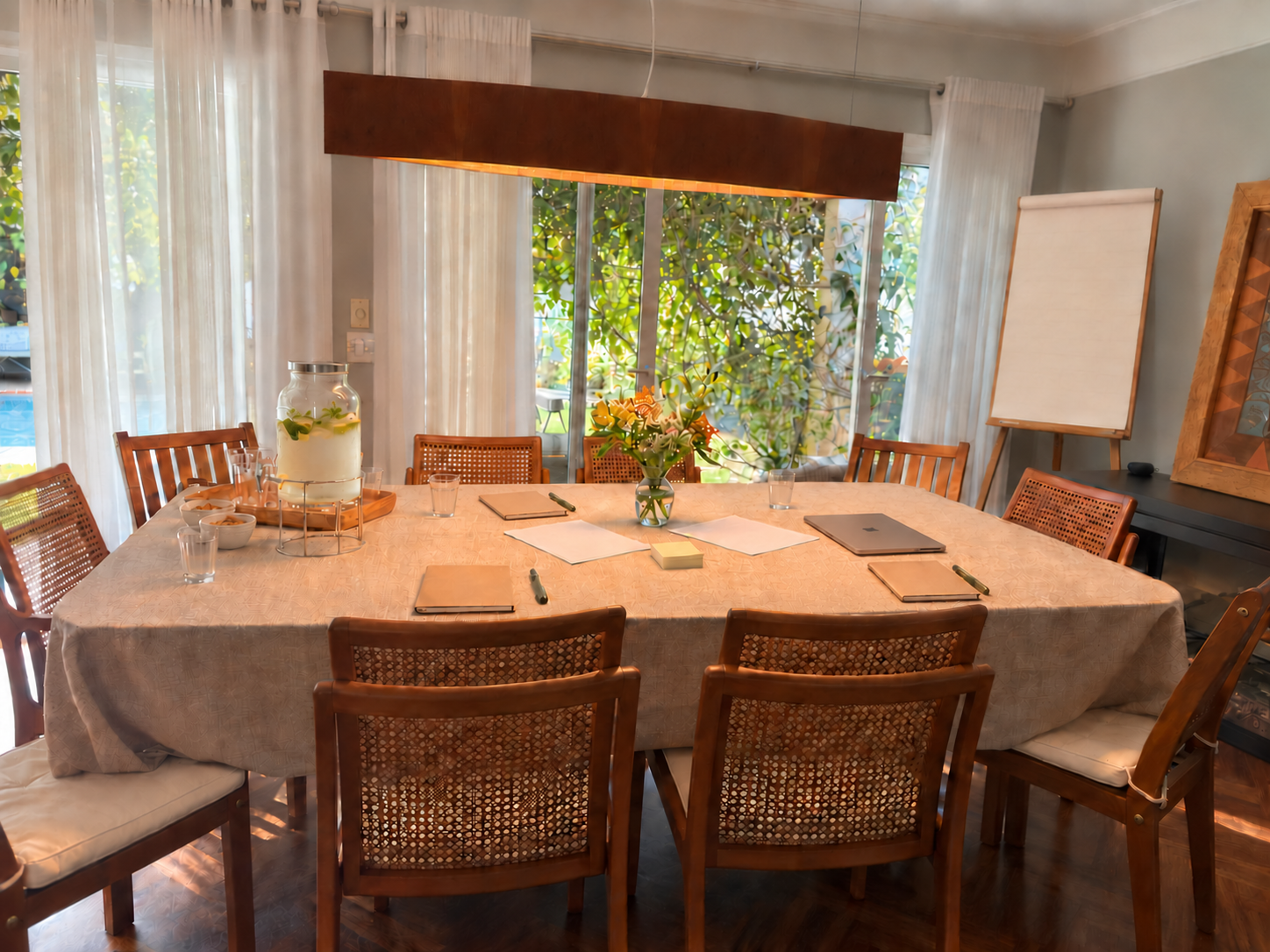 Mesa preparada com cadernos, papéis e cadeiras para uma reunião